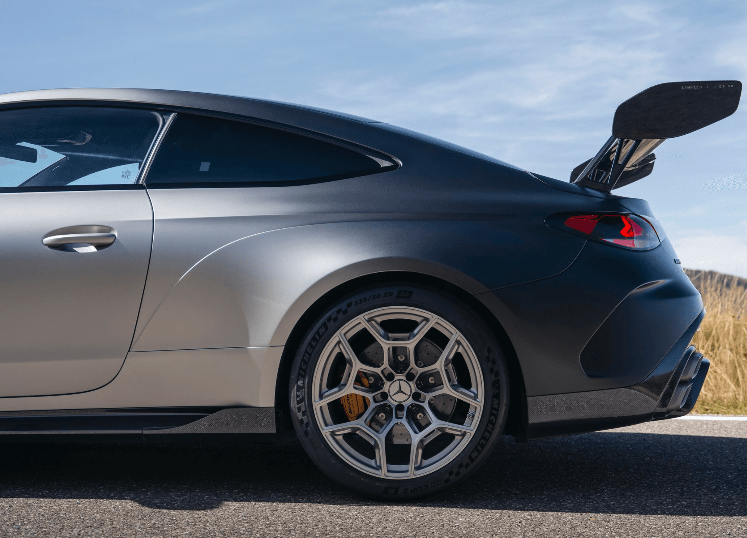 Manually adjustable carbon rear wing on a competition coupe